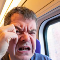 A middle aged man on a train crying while taking it (1).jpg